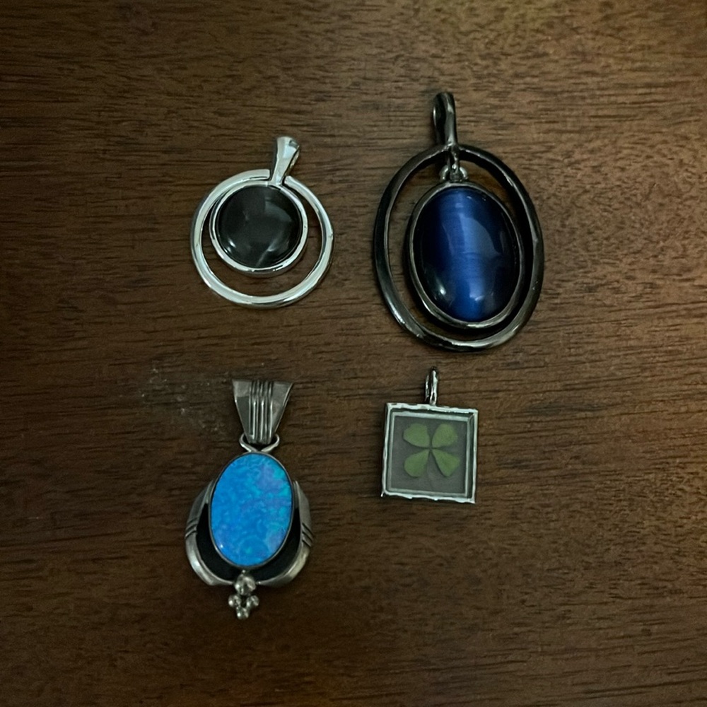 Lot of four pendants including blue opal, black onyx, and kyanite.